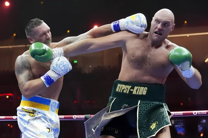 Two boxers stand opposite each other