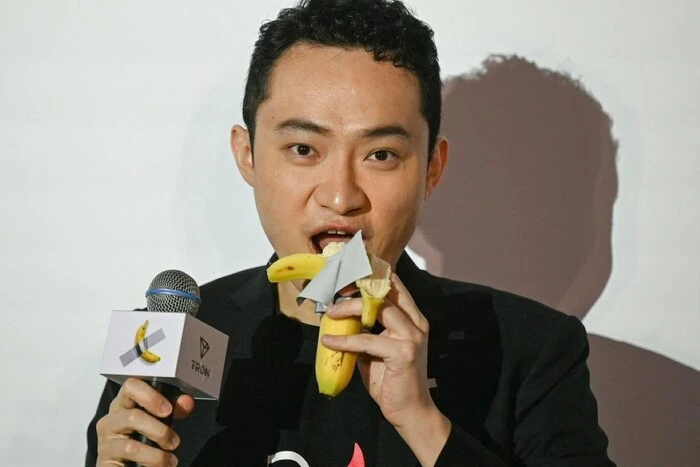 Crypto entrepreneur eats banana from art object