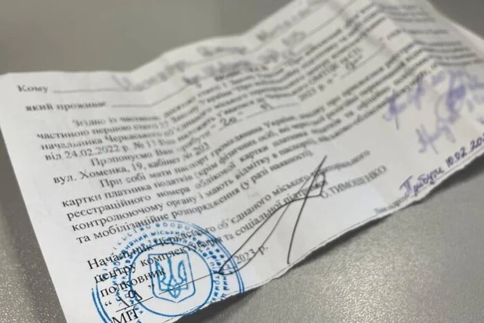 A man signs documents at the military enlistment office